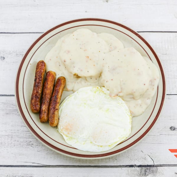 Humpty Dumpty Kitchen's breakfast plate with biscuits and gravy, sausage links, and two fried eggs.