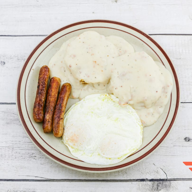 Humpty Dumpty Kitchen's breakfast plate with biscuits and gravy, sausage links, and two fried eggs.
